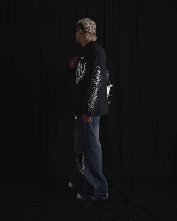 black oversized full-sleeve graphic T-shirt with distressed white front print and sleeve designs on a male model.