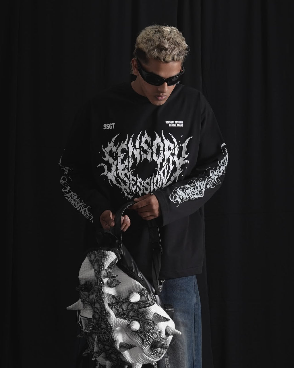 black oversized full-sleeve graphic T-shirt with distressed white front print and sleeve designs on a male model.