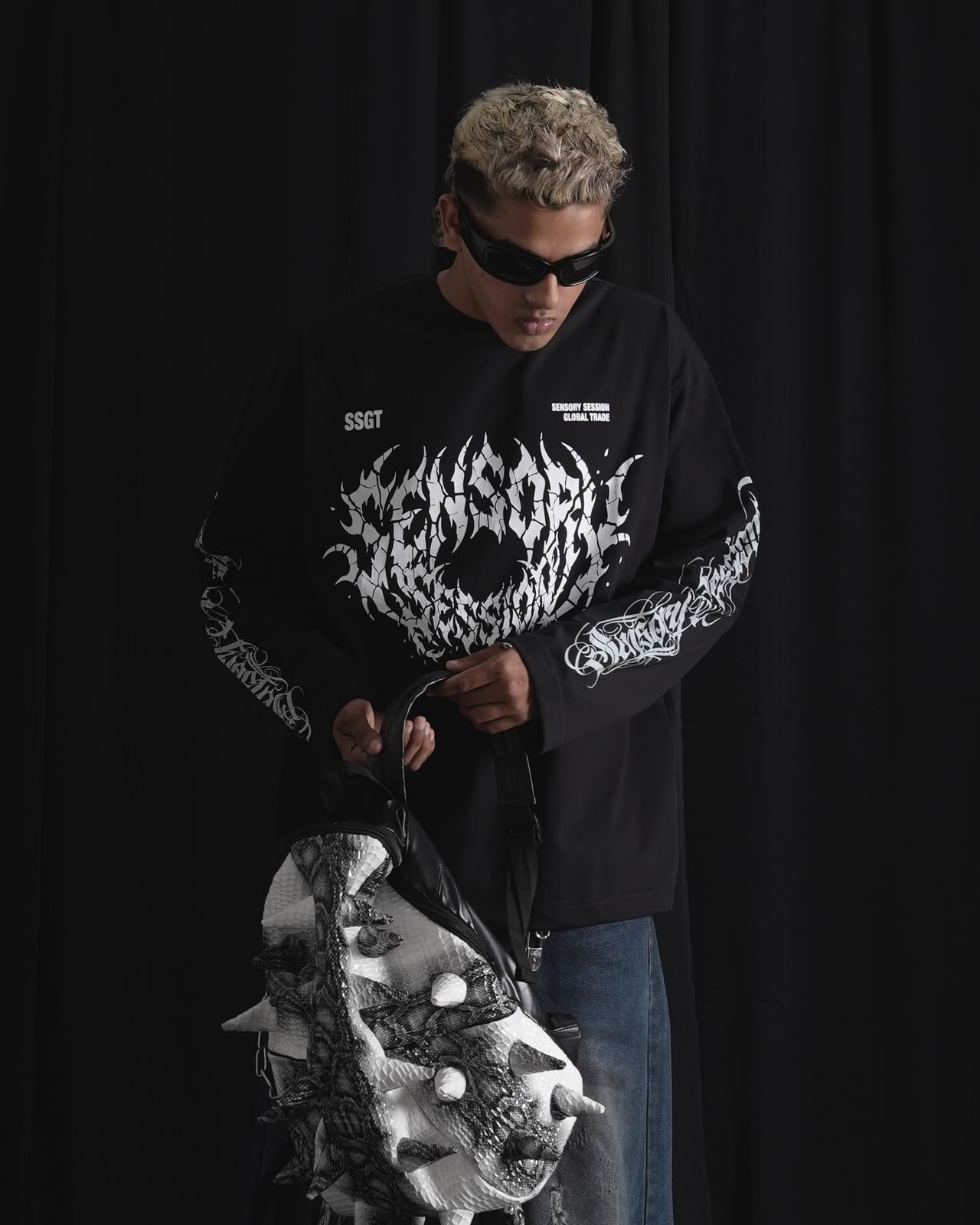 black oversized full-sleeve graphic T-shirt with distressed white front print and sleeve designs on a male model.