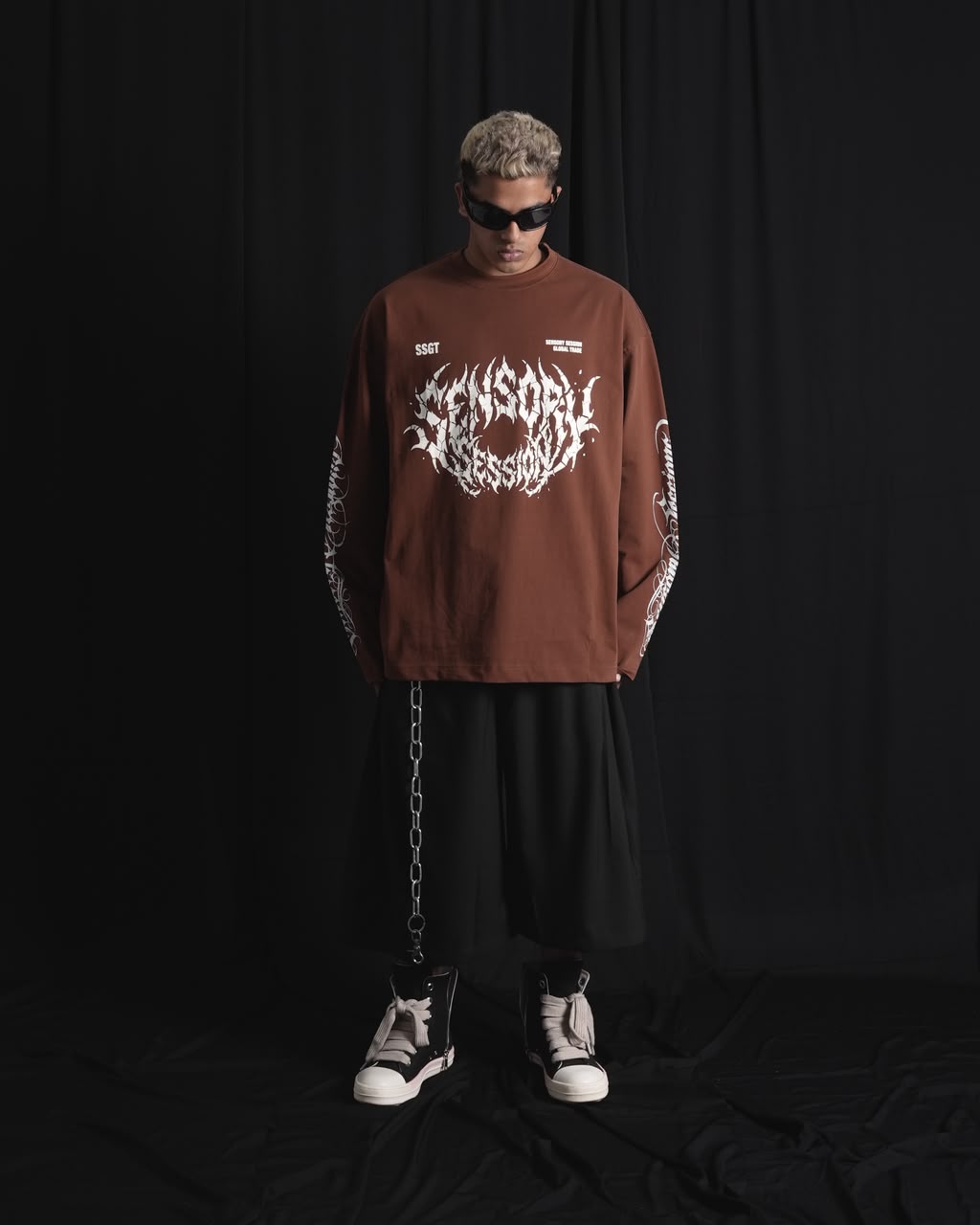 BROWN oversized full-sleeve graphic T-shirt with distressed white front print and sleeve designs on a male 