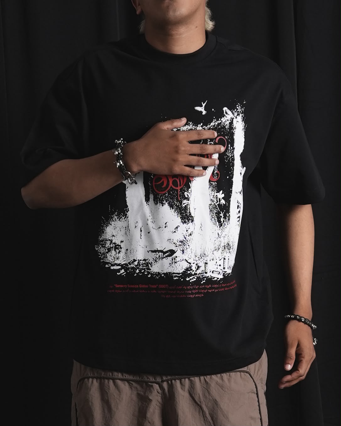 Black oversized graphic T-shirt with bold white and red urban graffiti print styled on a male model.