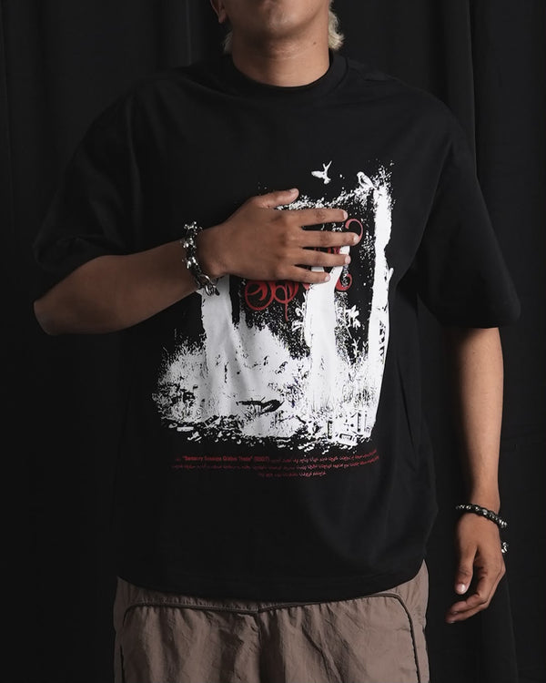 Black oversized graphic T-shirt with bold white and red urban graffiti print styled on a male model.