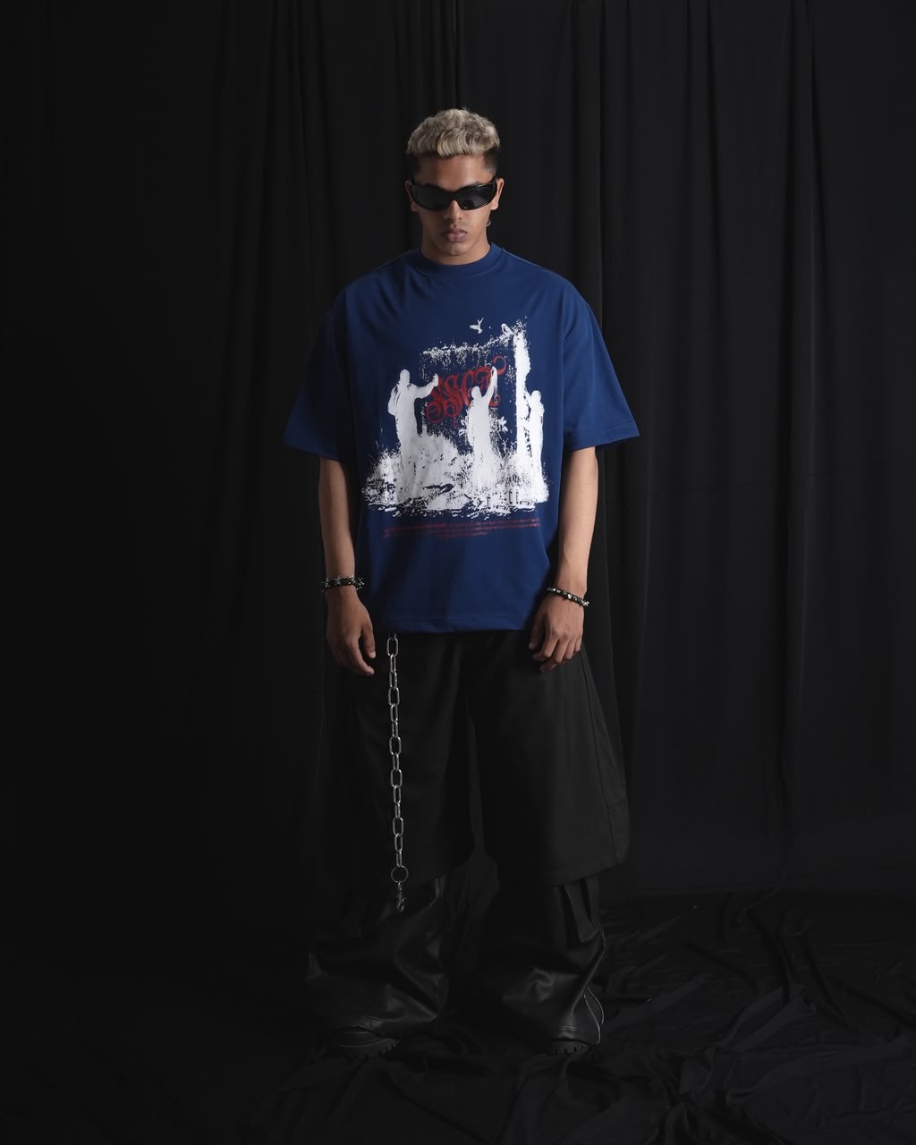 blue oversized graphic T-shirt with bold white and red urban graffiti print styled on a male model.
