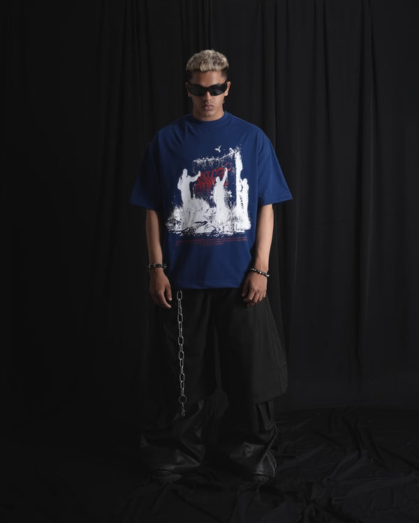 blue oversized graphic T-shirt with bold white and red urban graffiti print styled on a male model.