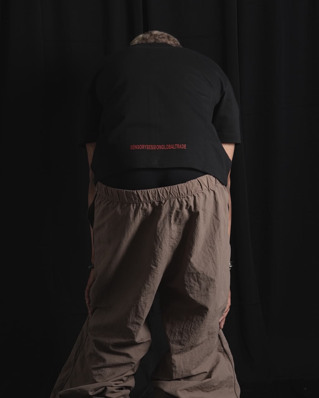 Black oversized graphic T-shirt with bold white and red urban graffiti print styled on a male model.