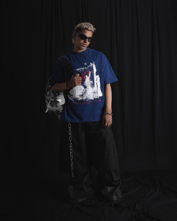 blue oversized graphic T-shirt with bold white and red urban graffiti print styled on a male model.
