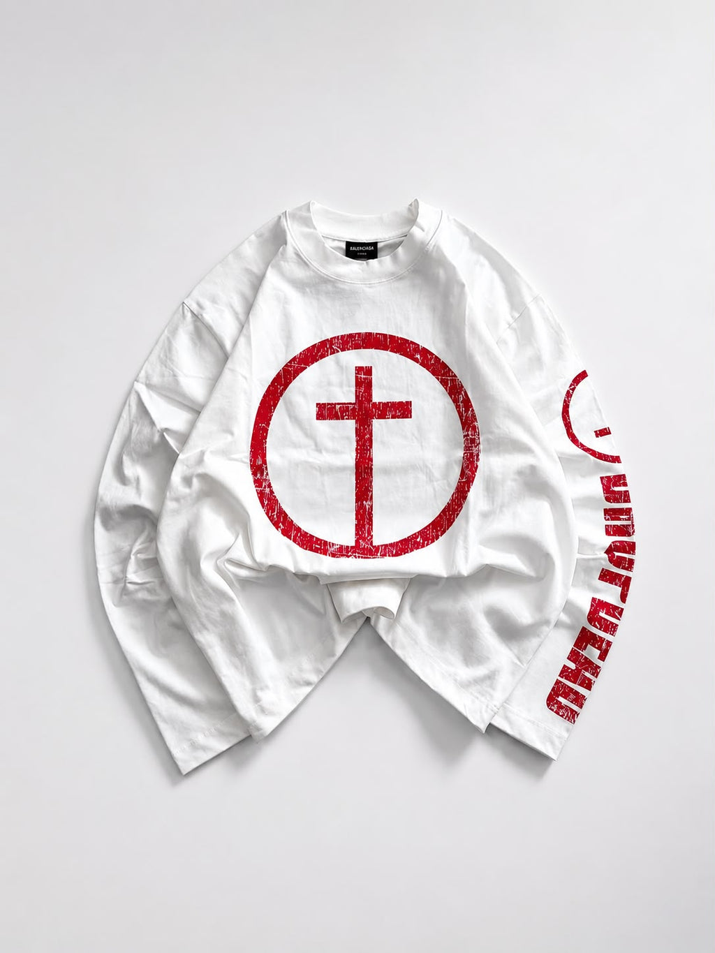 White oversized long sleeve graphic T-shirt featuring a distressed red cross circle front print and bold red sleeve graphic, laid flat on a white background for streetwear fashion.