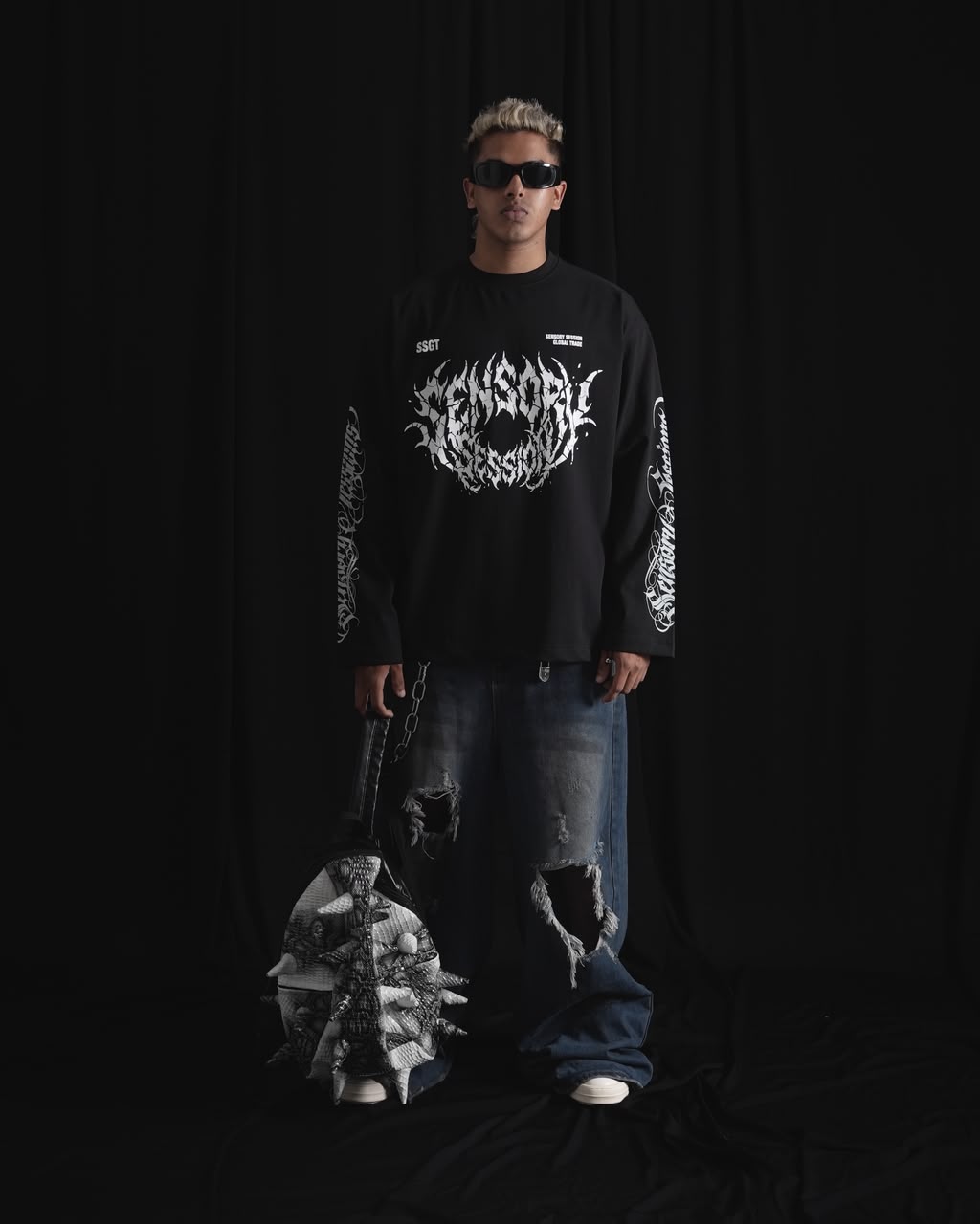 balack oversized full-sleeve graphic T-shirt with distressed white front print and sleeve designs on a male model.