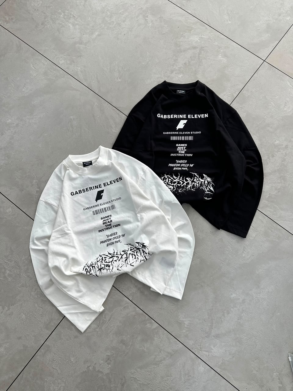 Black full-sleeve graphic T-shirt styled with baggy shorts for a modern streetwear look.