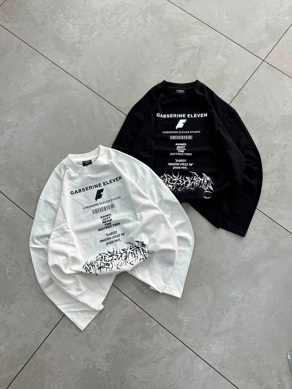 Black full-sleeve graphic T-shirt styled with baggy shorts for a modern streetwear look.