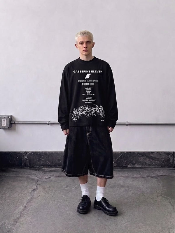 Black full-sleeve graphic T-shirt styled with baggy shorts for a modern streetwear look.
